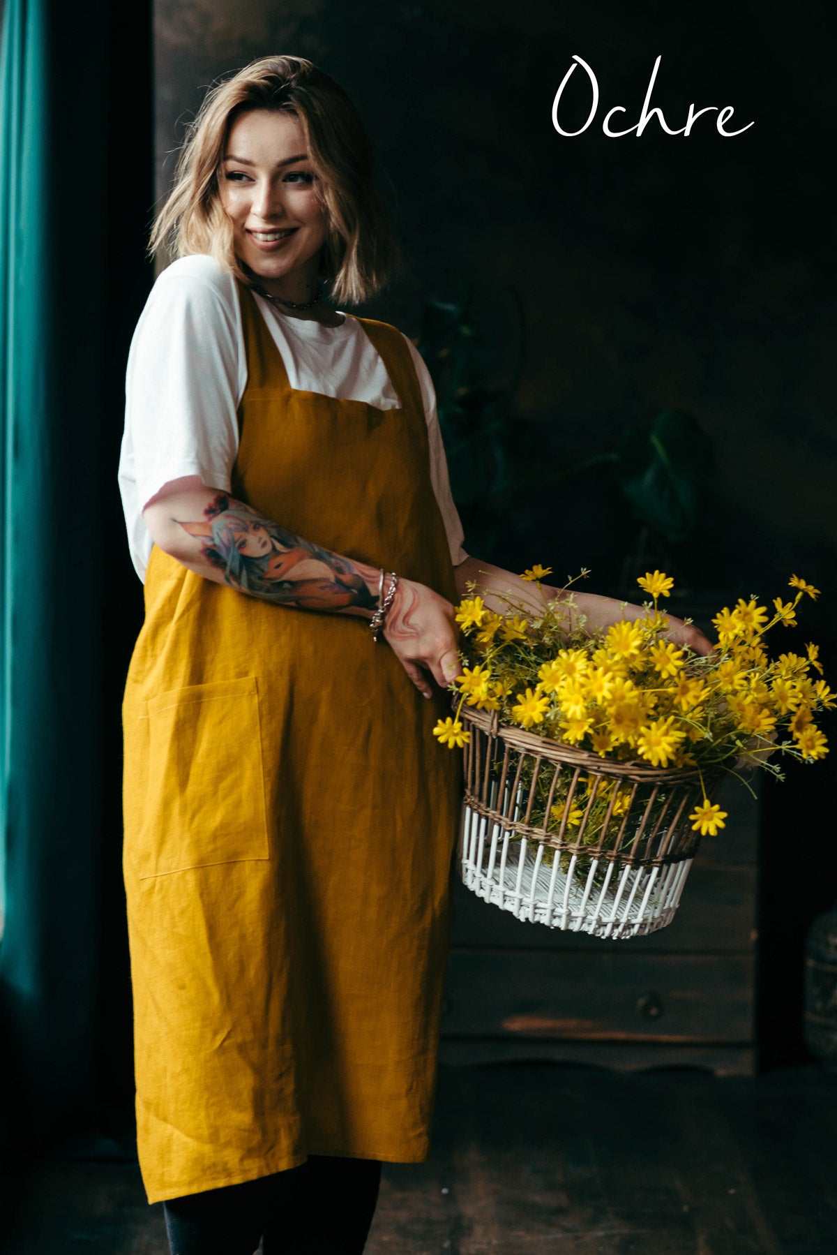 Woman in a yellow apron holding a basket of flowers
