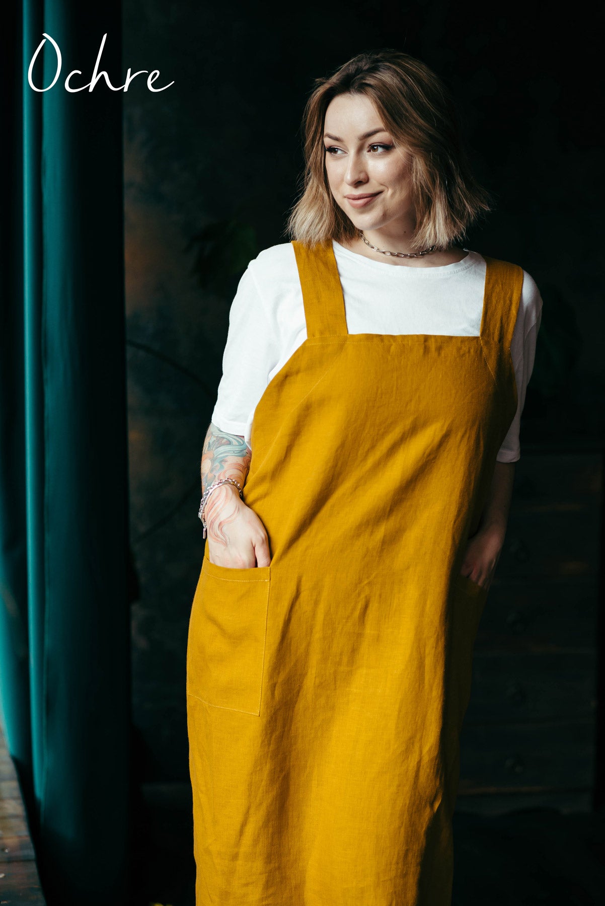 Woman in ochre linen pinafore apron front view
