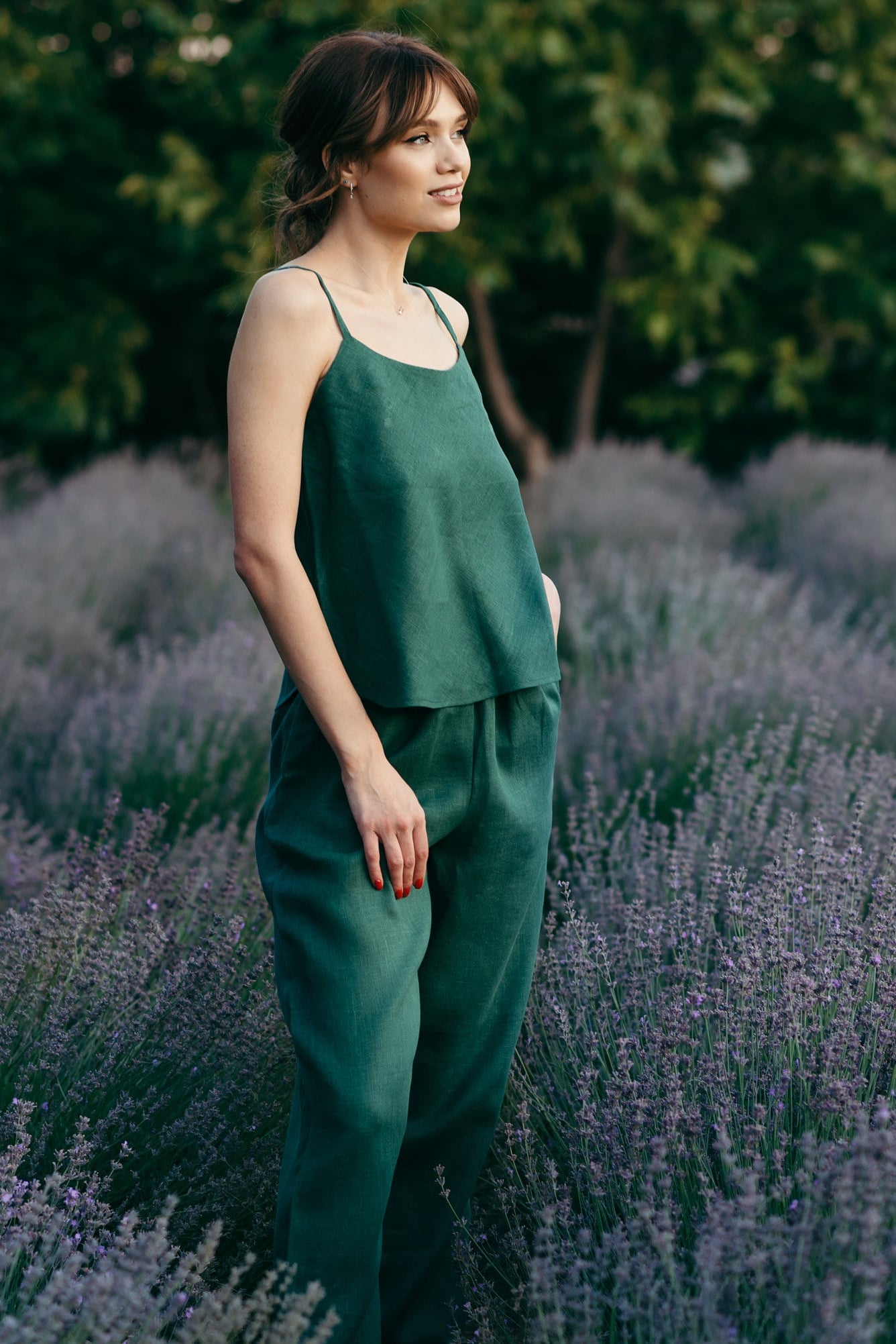 Woman in a green loose linen pyjamas ser standing in a lavender field