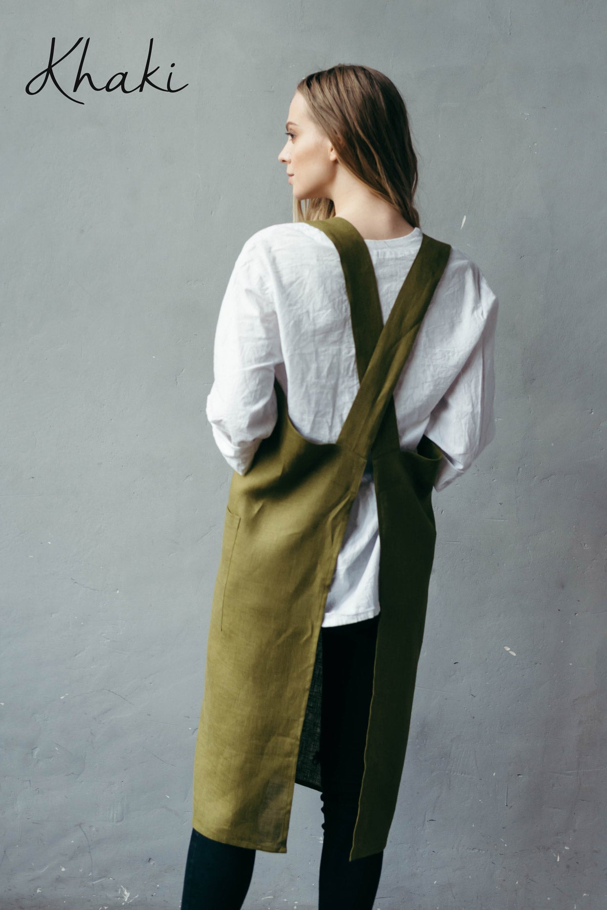 Artist wearing a natural khaki linen pinafore apron with pockets