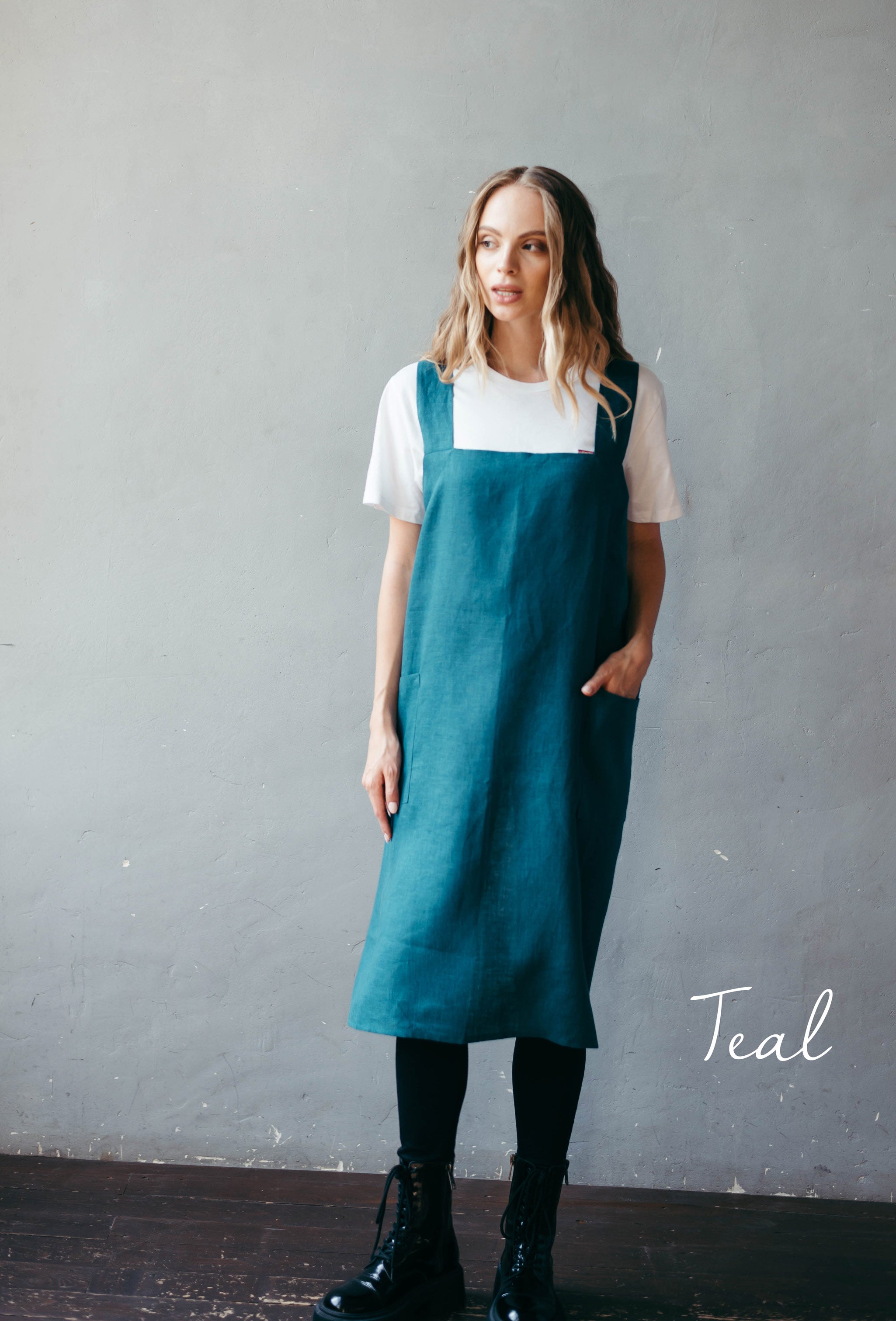 Woman wearing teal linen cross-back apron, sustainable European linen.