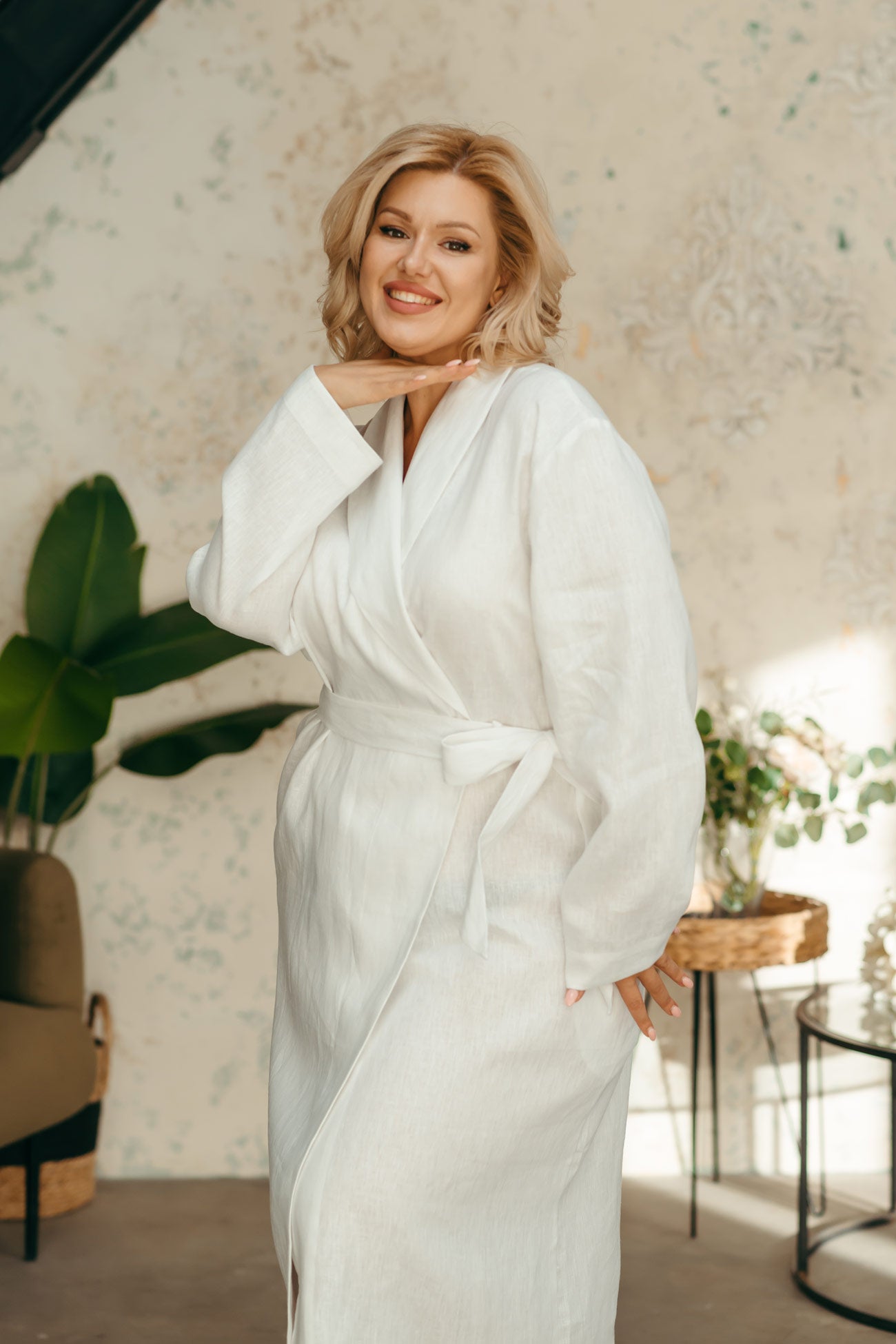 Woman in a white linen spa robe with shawl collar, soft European linen dressing gown.