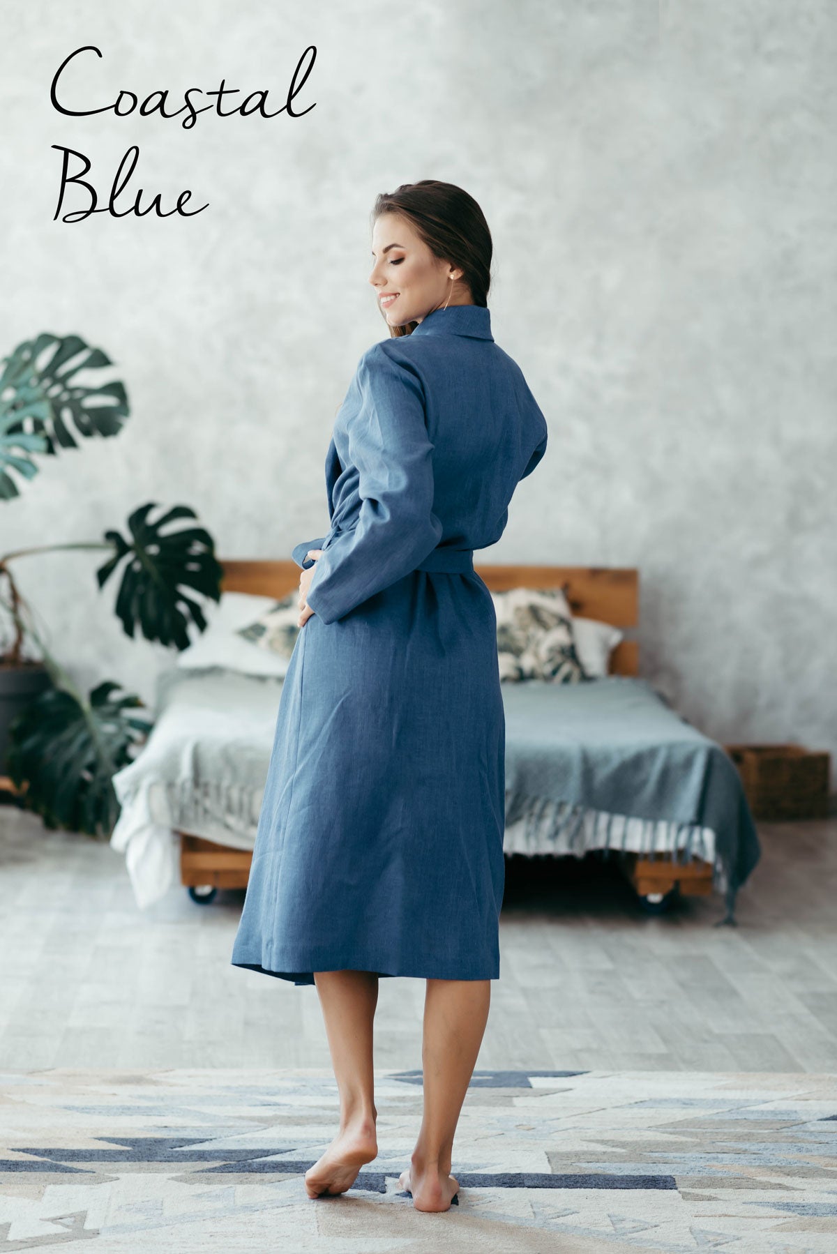 Woman wearing a blue linen bathrobe in a bedroom setting with 'Coastal Blue' text.