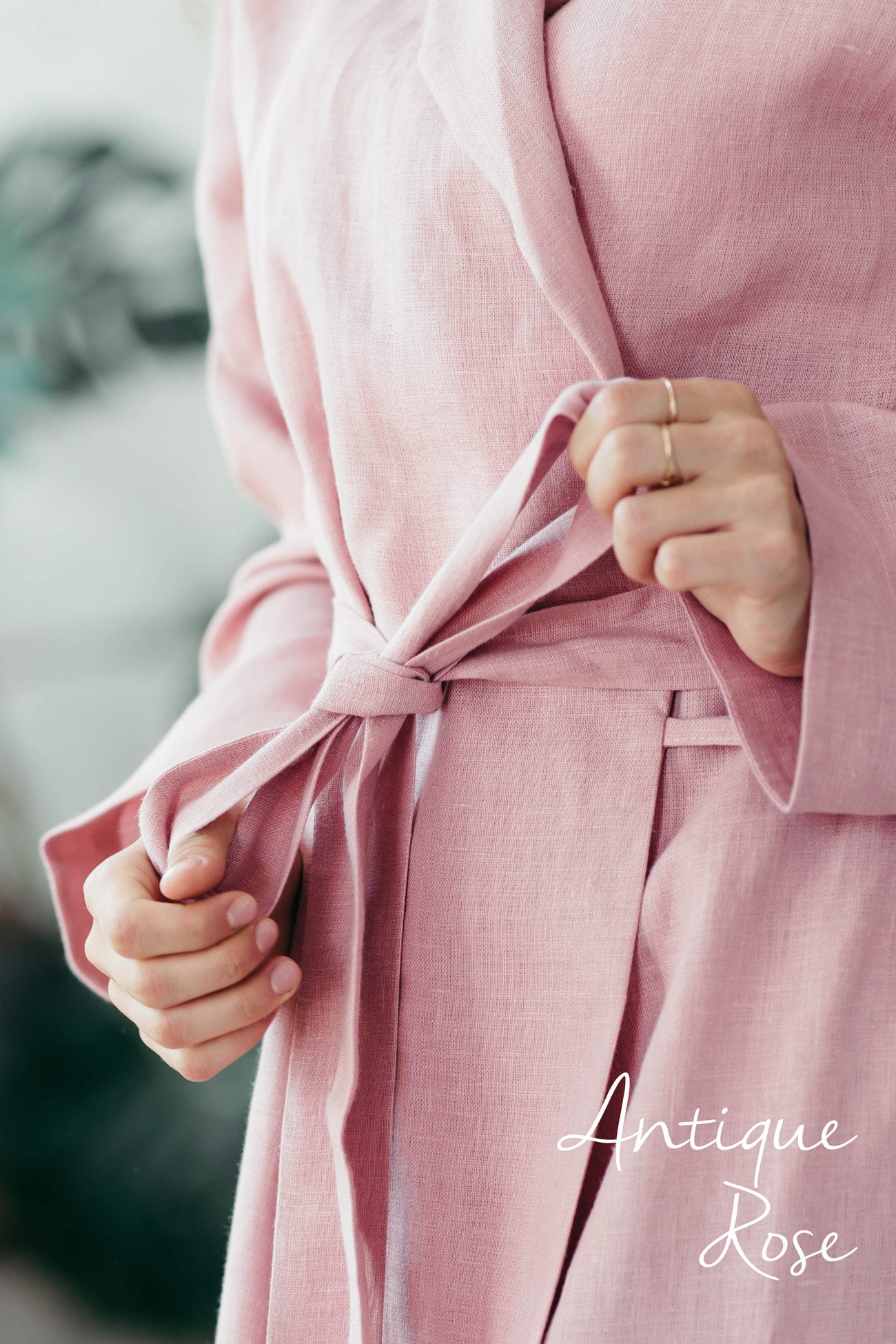 Close-up of a pink linen bathrobe with 'Antique Rose' text on a blurred background
