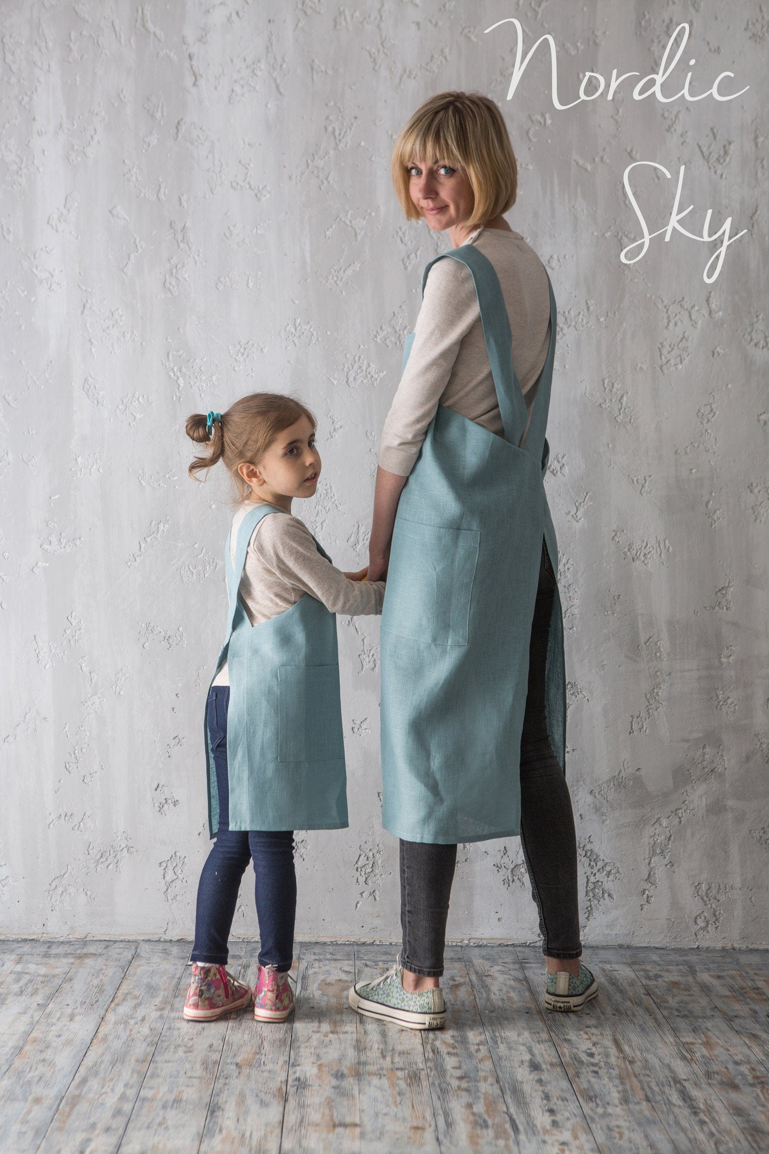 Mother and daughter matching linen pinafores in blue and natural