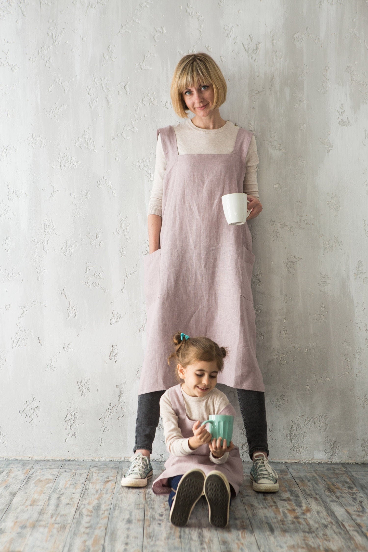 Mother and daughter in muted pale pink linen pinafores