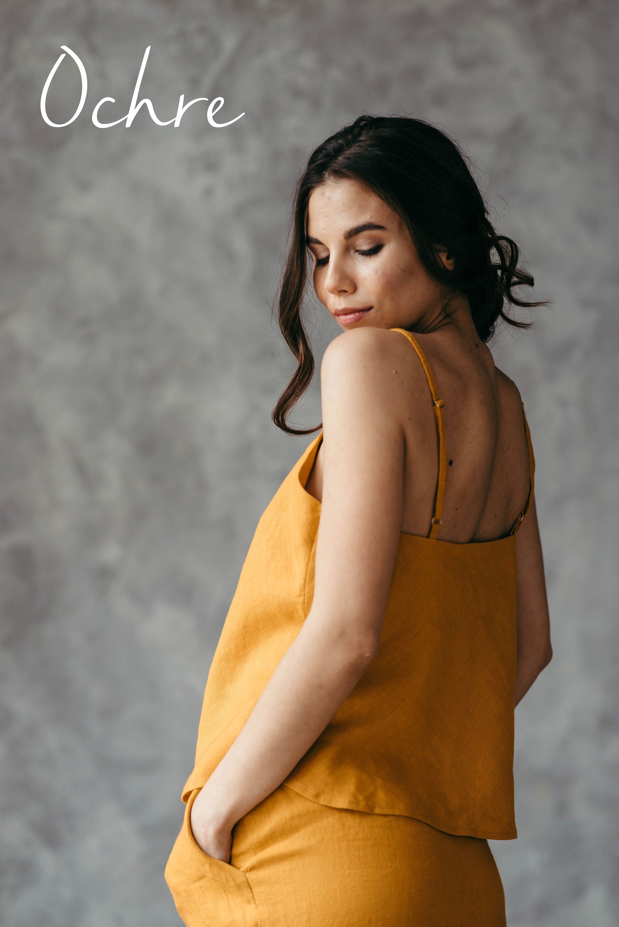 Woman wearing an ochre-colored pyjama top and oversizes lounge pants with pockets.