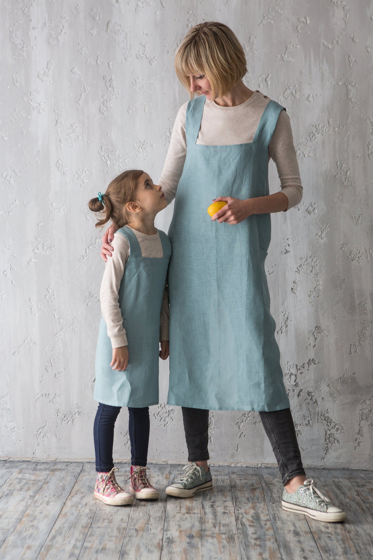 Mother and daughter in duck egg green linen pinafore aprons